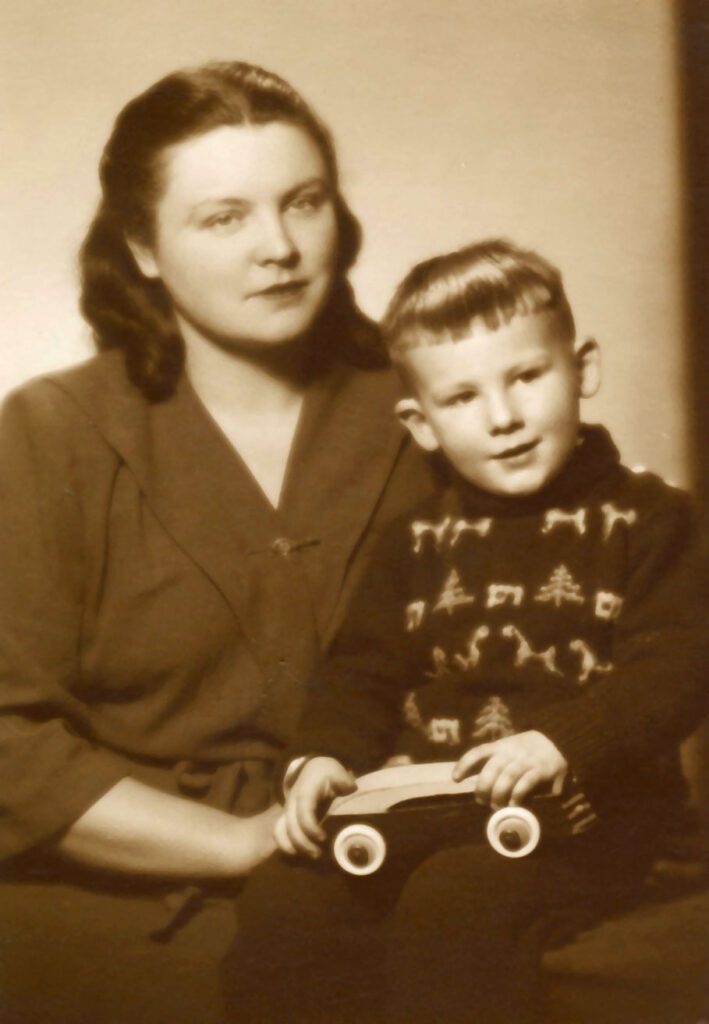 Portrait in sepia color of young woman wearing a dress with her small son on her lap.