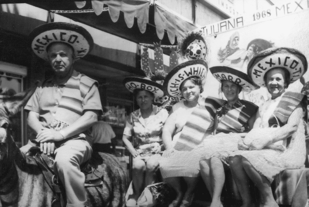 Tourists in Mexico wearing hats, four women riding in a carriage with man on donkey.