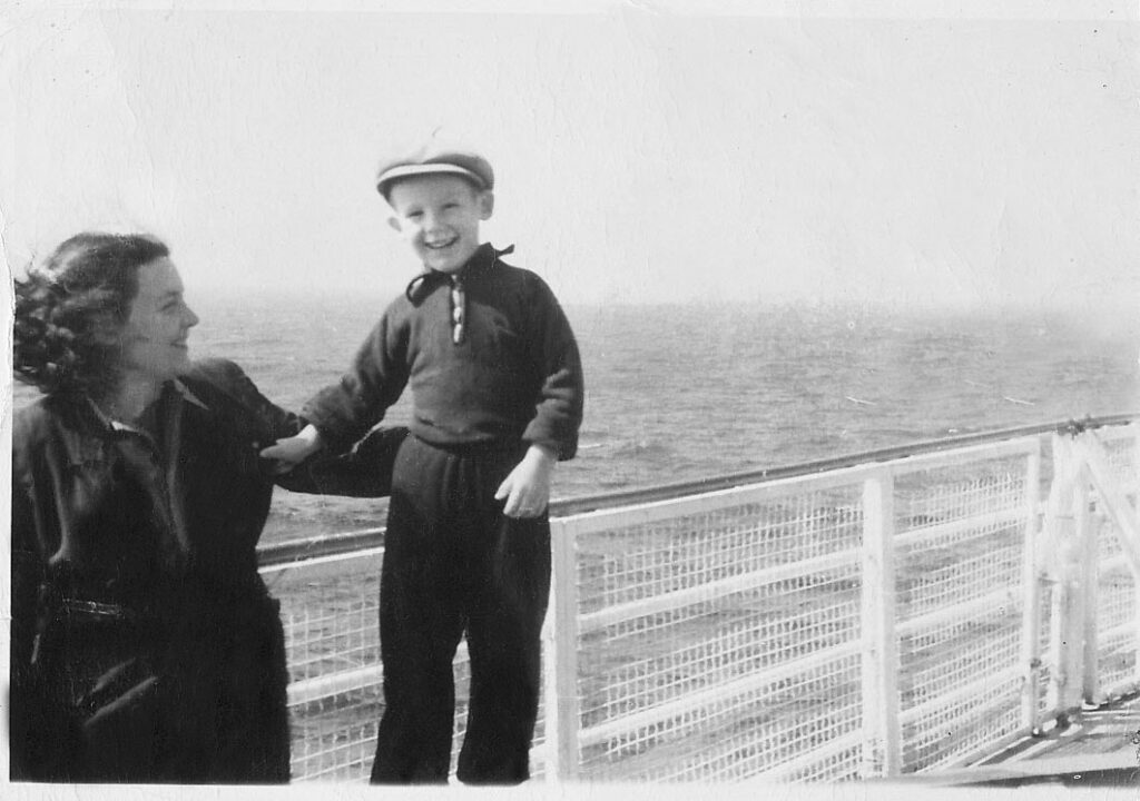 Young woman and her small son onboard a ship on the ocean.