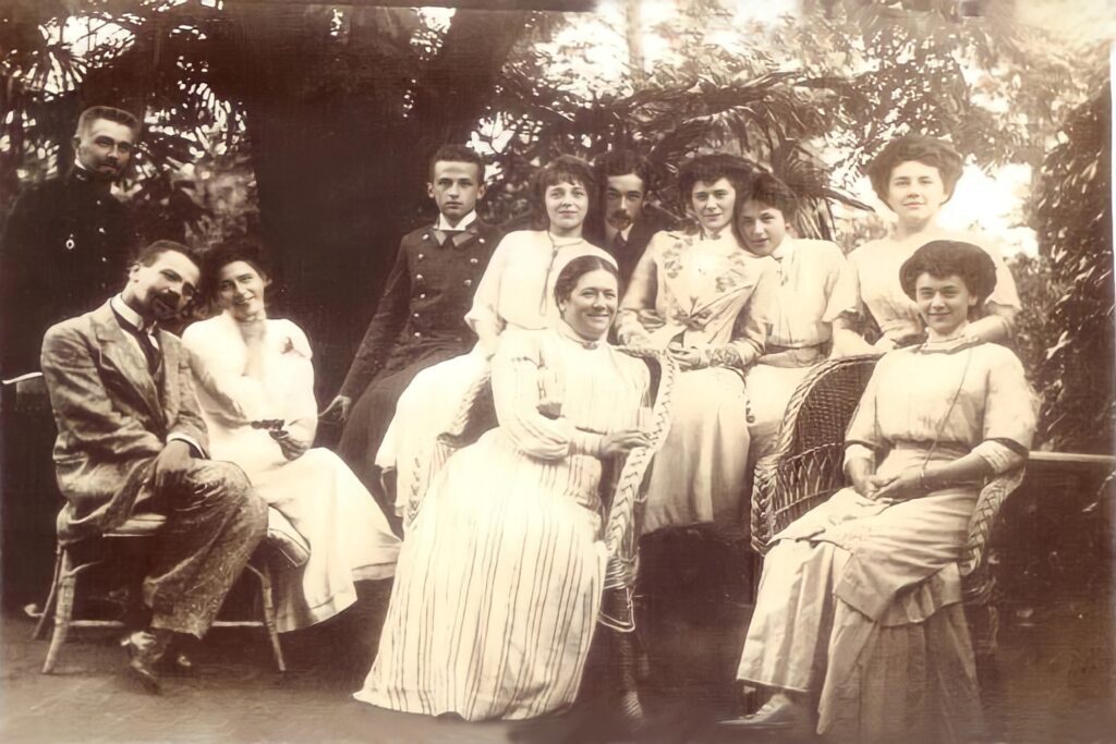 A family in 1910 sitting outside in a garden.