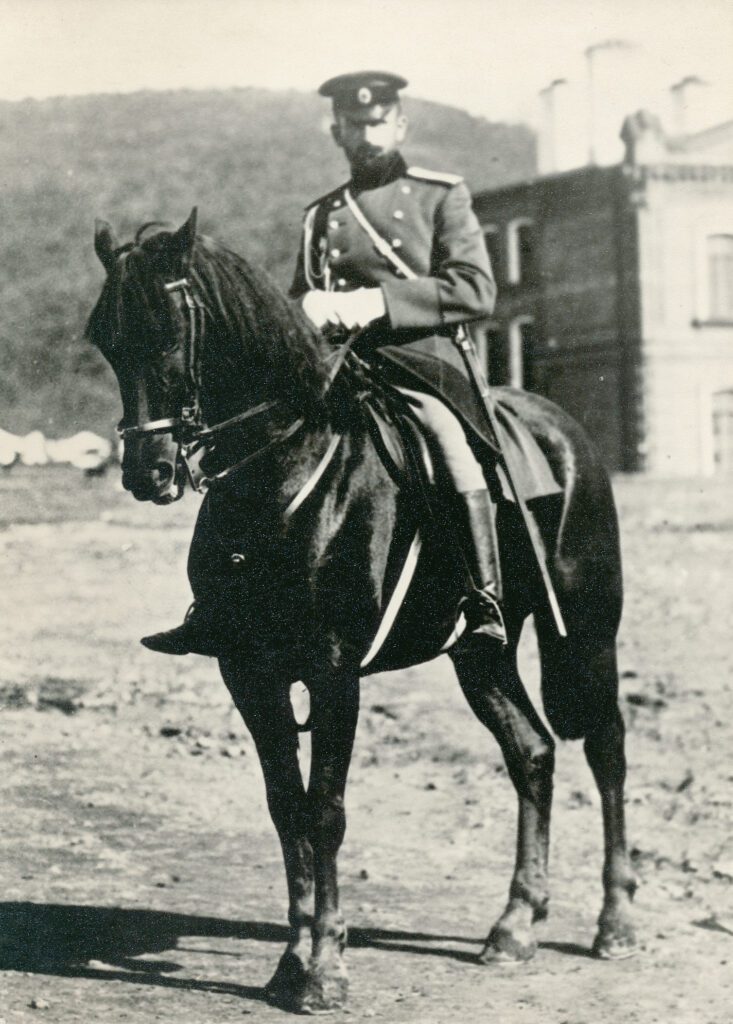 Old photo of a nineteenth century Russian officer on a beautiful black horsse.